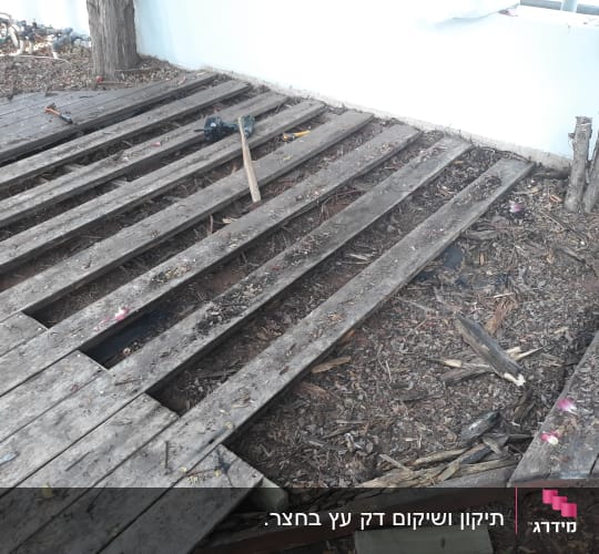 קרשים מעץ בגינה עם כלי עבודה על הקרקע